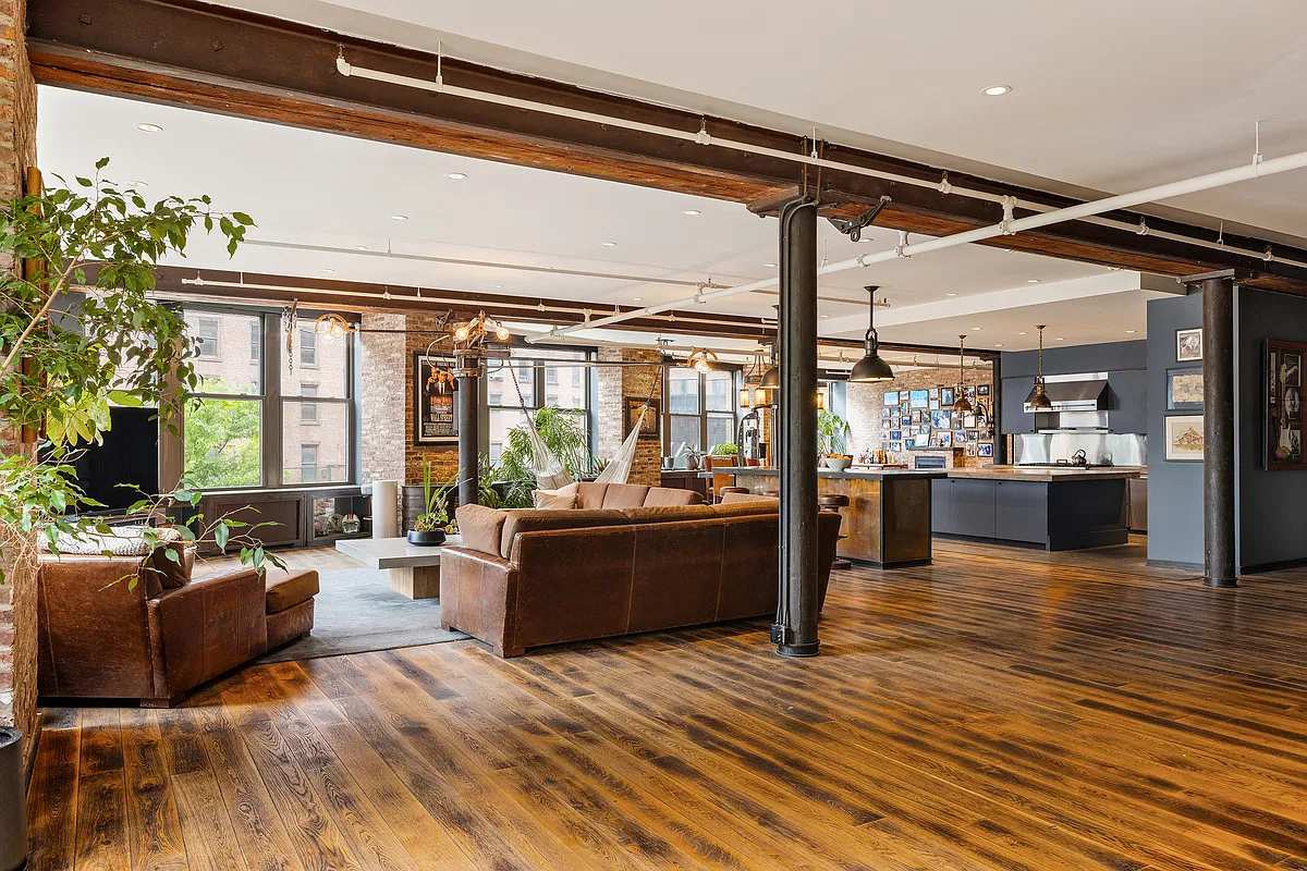 Open great room with cast-iron columns, sofas and the kitchen beyond