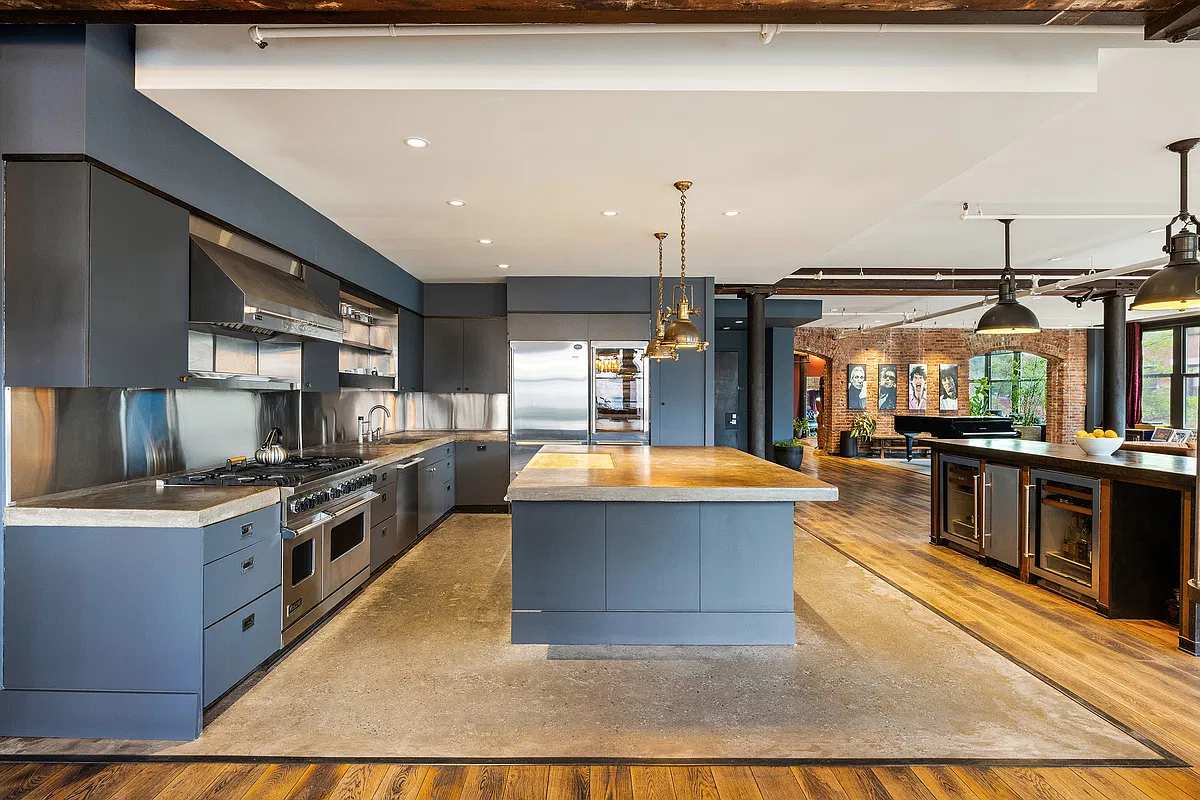 Chef's kitchen with a long stone island and a professional range