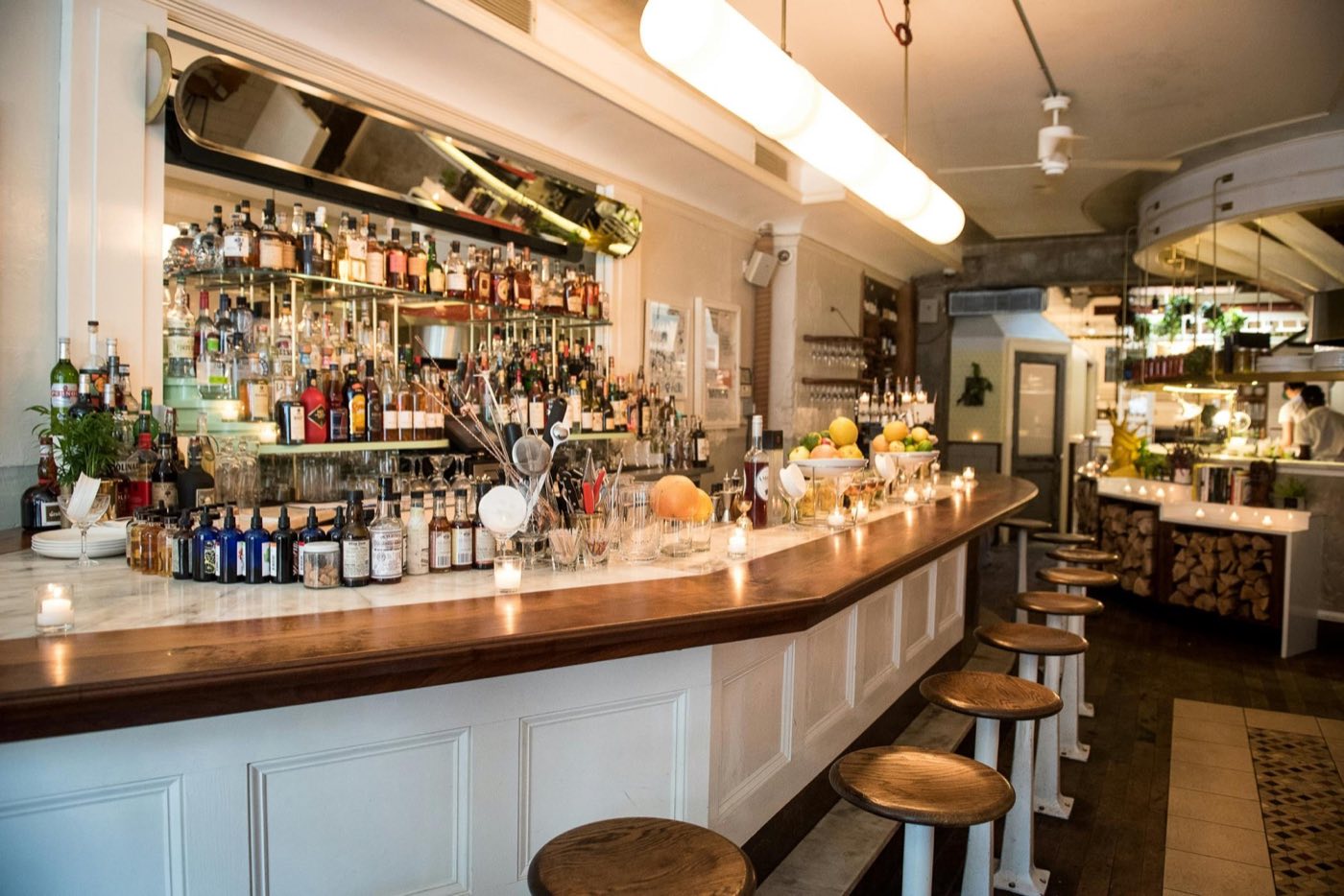 Curved marble bar with a mirrored back bar and stools at 21 Greenpoint