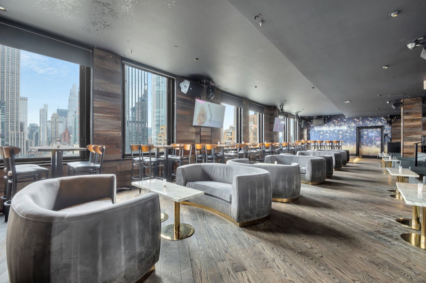 Enclosed penthouse lounge with grey sofas and window walls