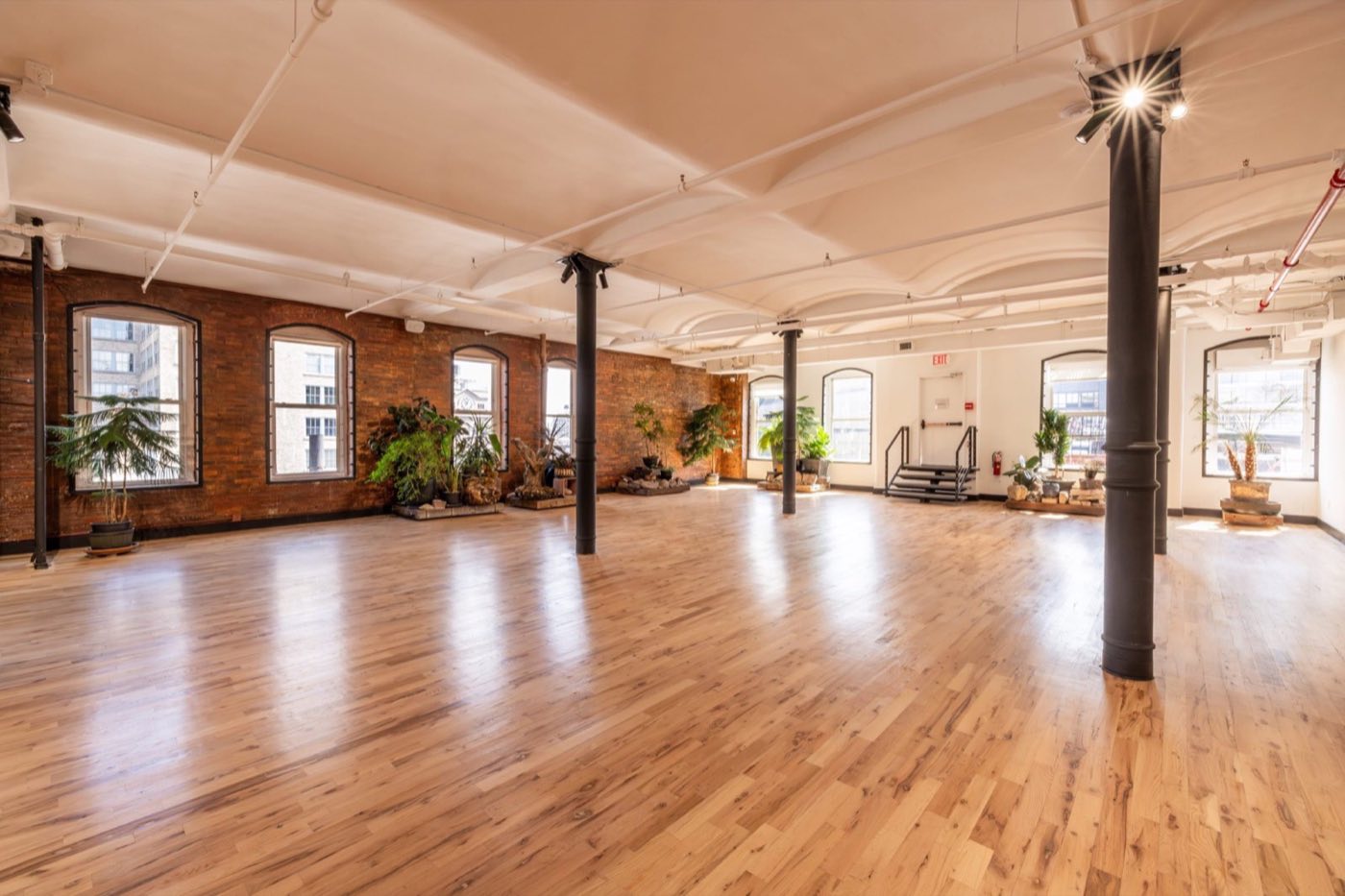 Empty loft with brick walls, arched windows and wood floors