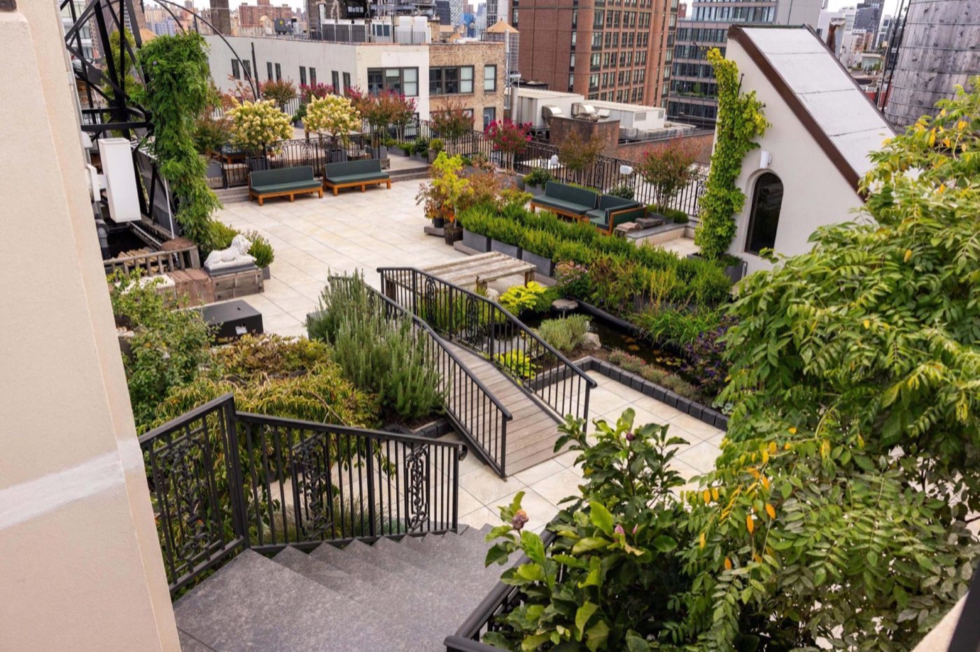 Rooftop garden terrace with stairs, planting beds and city views