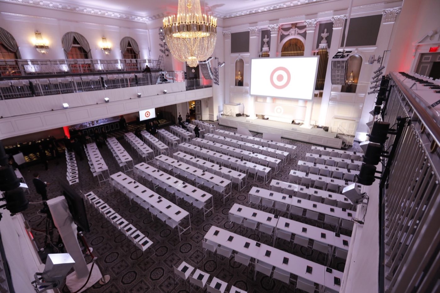 Ballroom in classroom setup with rows of tables facing a stage and screen