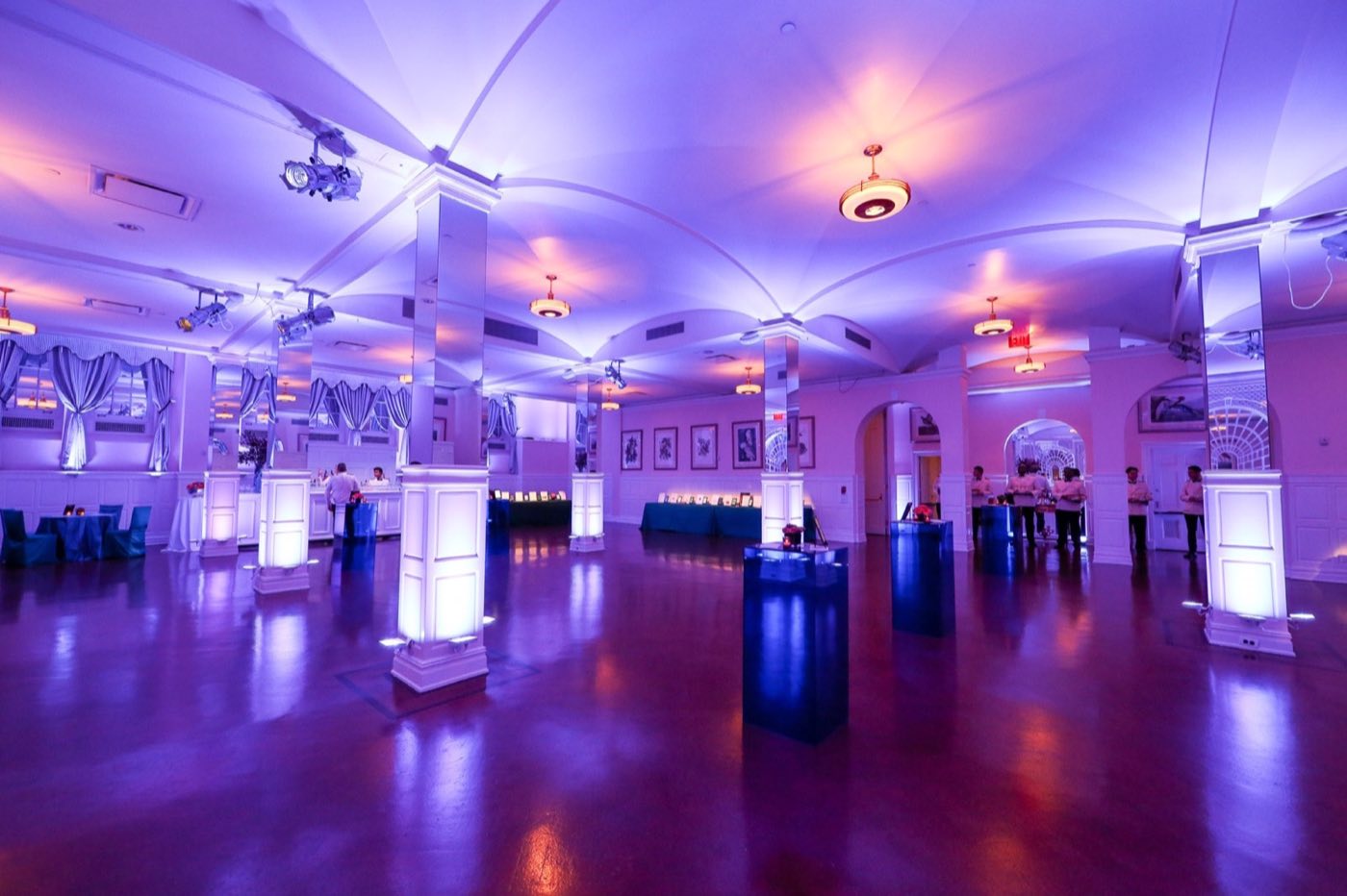 Empty Arcade room with columns, arched lattice windows and cocktail tables