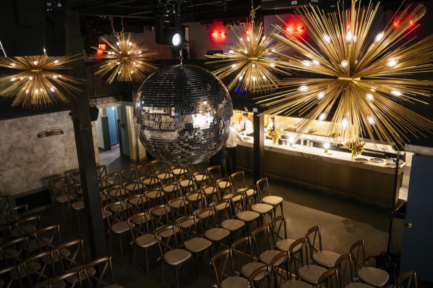 Main room set theater style with rows of chairs, disco ball and starburst lights