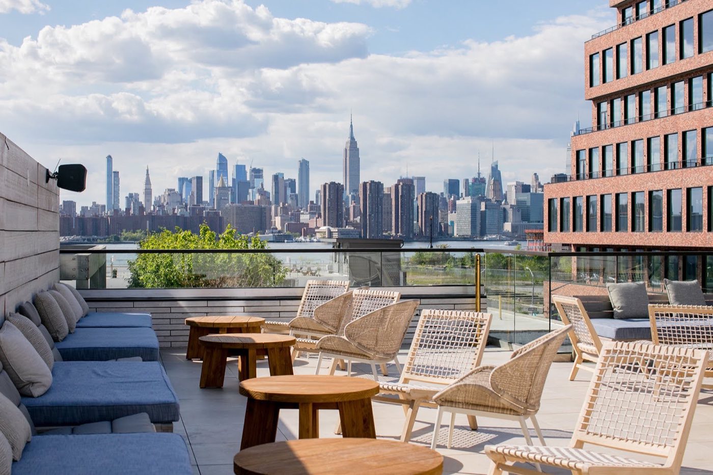 Rooftop terrace lounge seating with the Manhattan skyline across the river