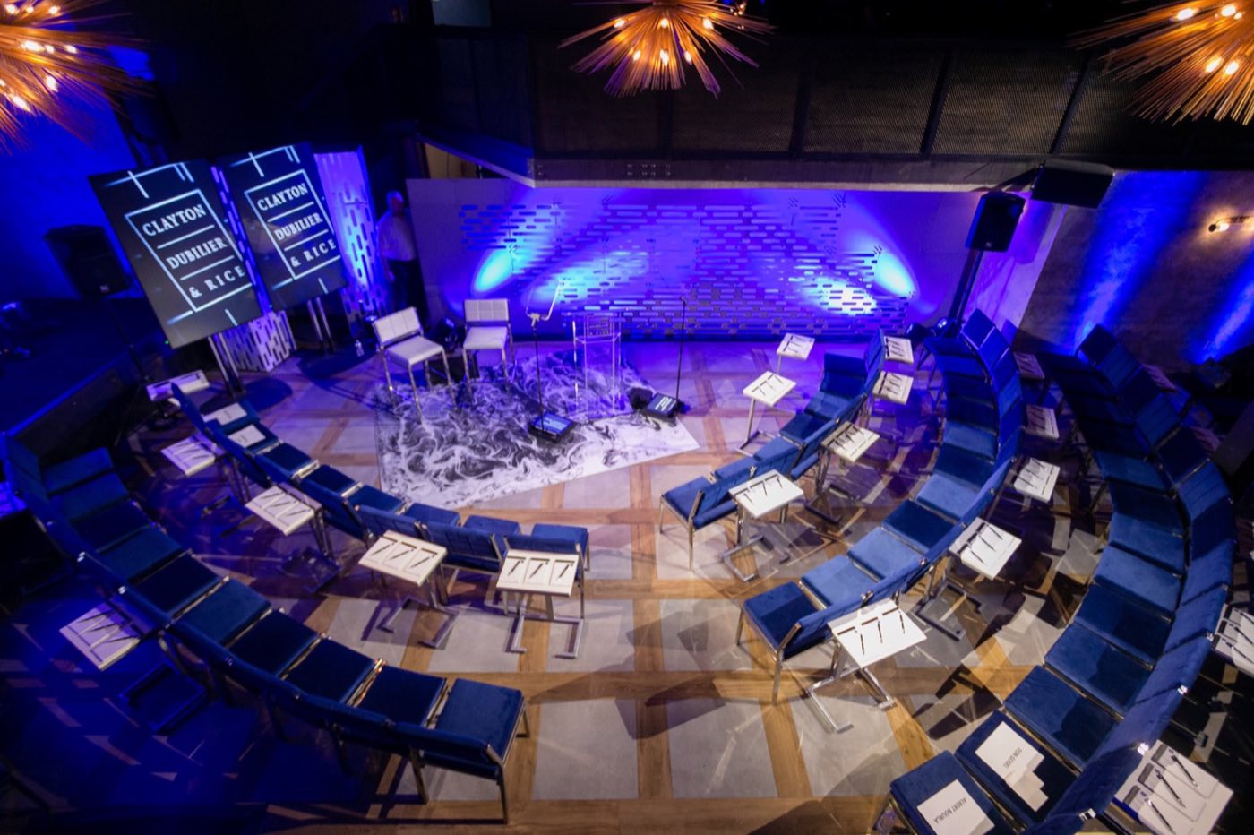 Main room set in the round for a live performance, with blue lighting