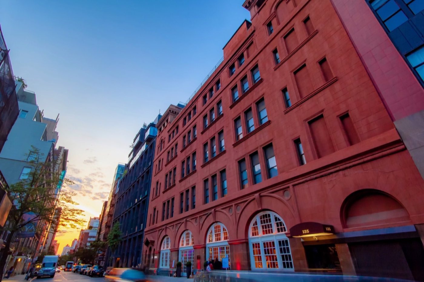 Red brick exterior of the building on West 18th Street at dusk