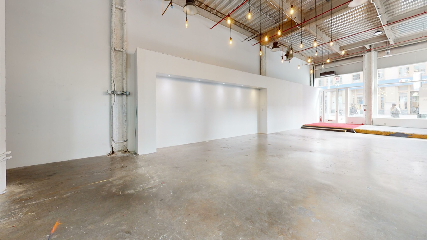 Open whitebox retail floor with lit feature wall and full height storefront windows