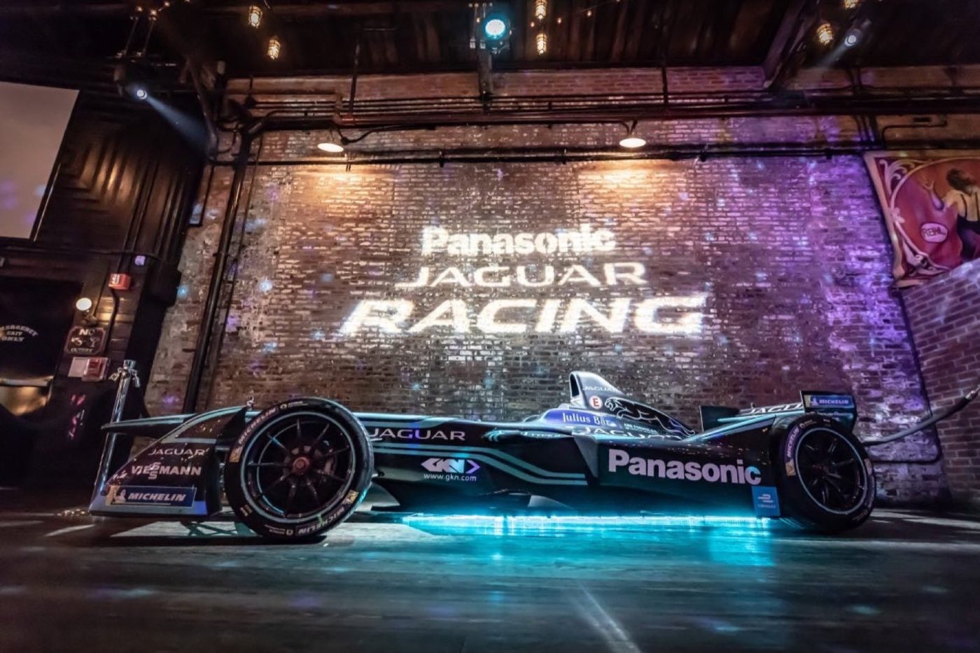 Race car displayed against the brick wall with projected branding