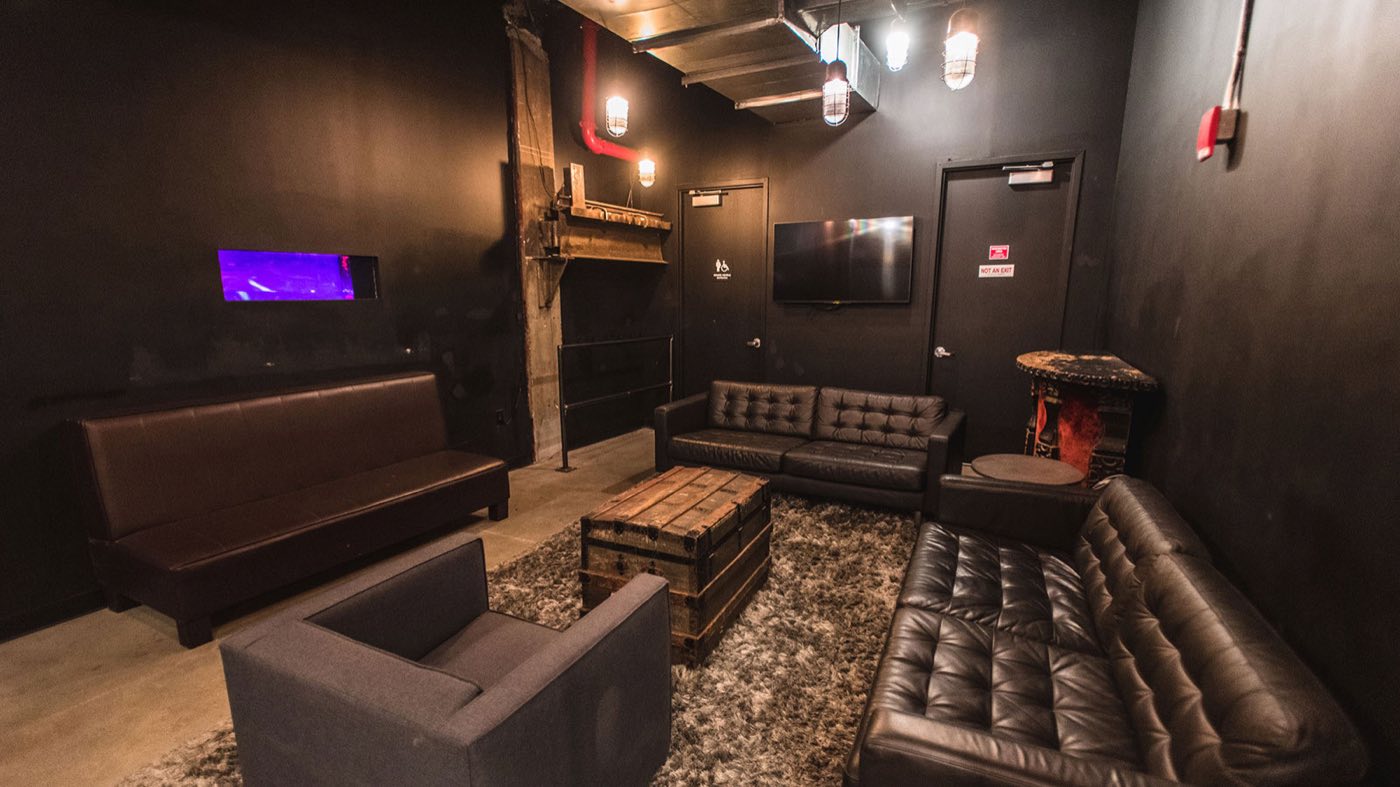 Private VIP room with leather sofas, rug and wood coffee table