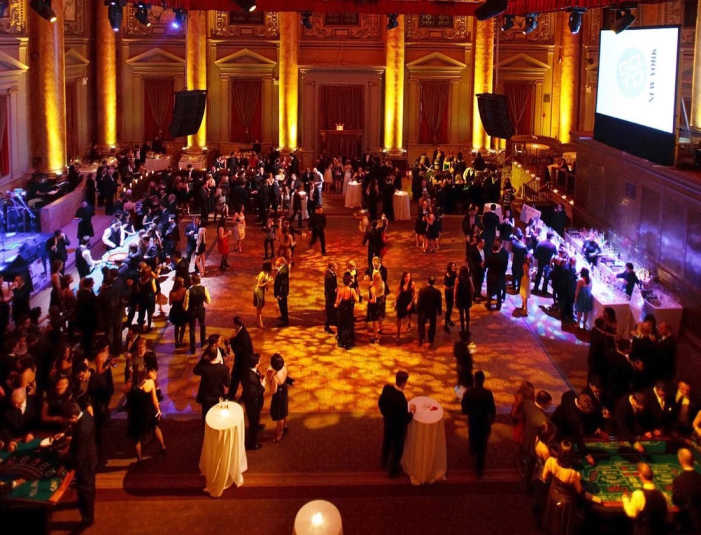 Standing reception filling the ballroom floor with a screen at one end