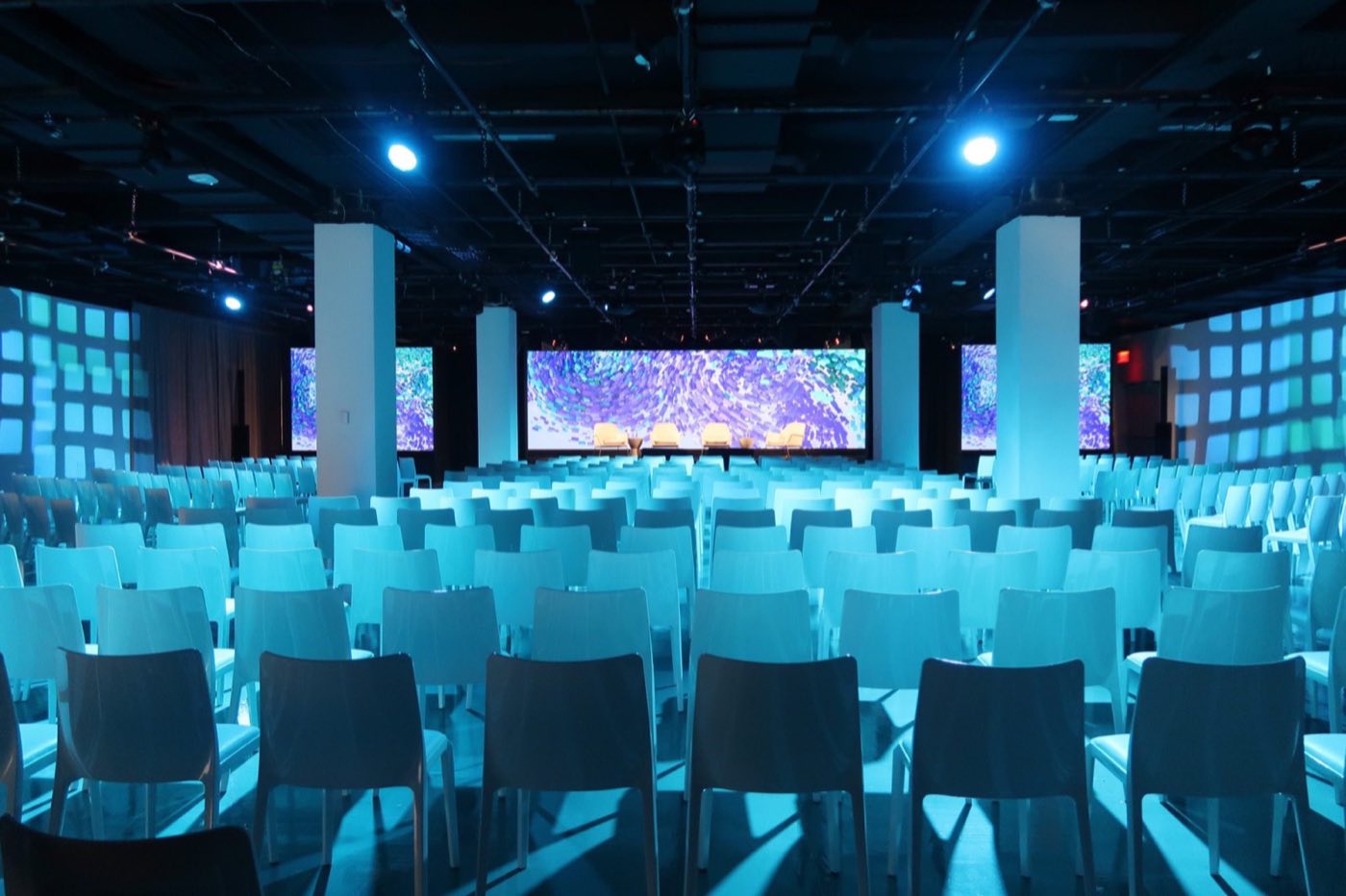 Second floor set theater style under blue light with wide stage screens