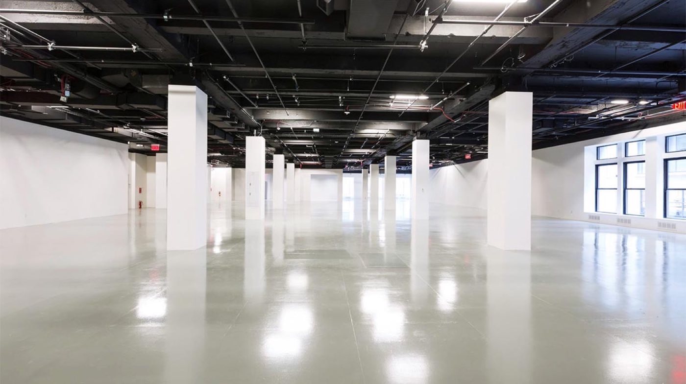 Empty second floor with white columns, epoxy floor and window wall