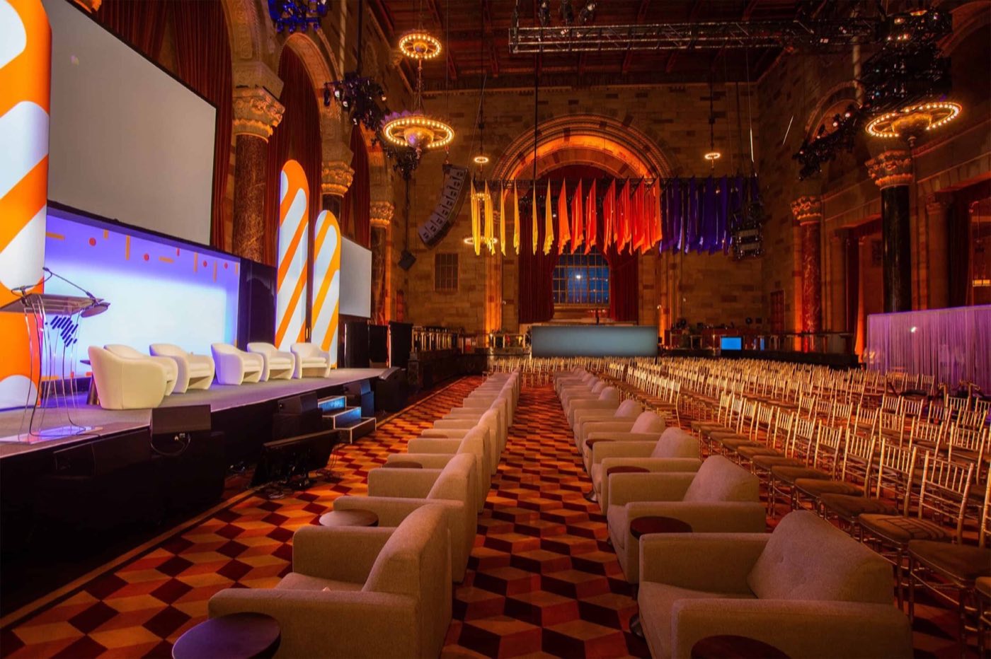 Main hall arranged for a conference with a stage, screens and rows of chairs