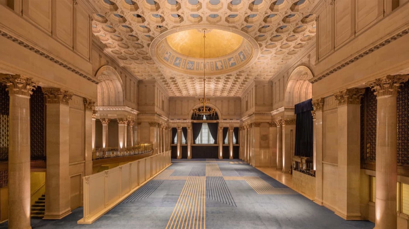 Empty great hall viewed end to end, with columns and a coffered ceiling
