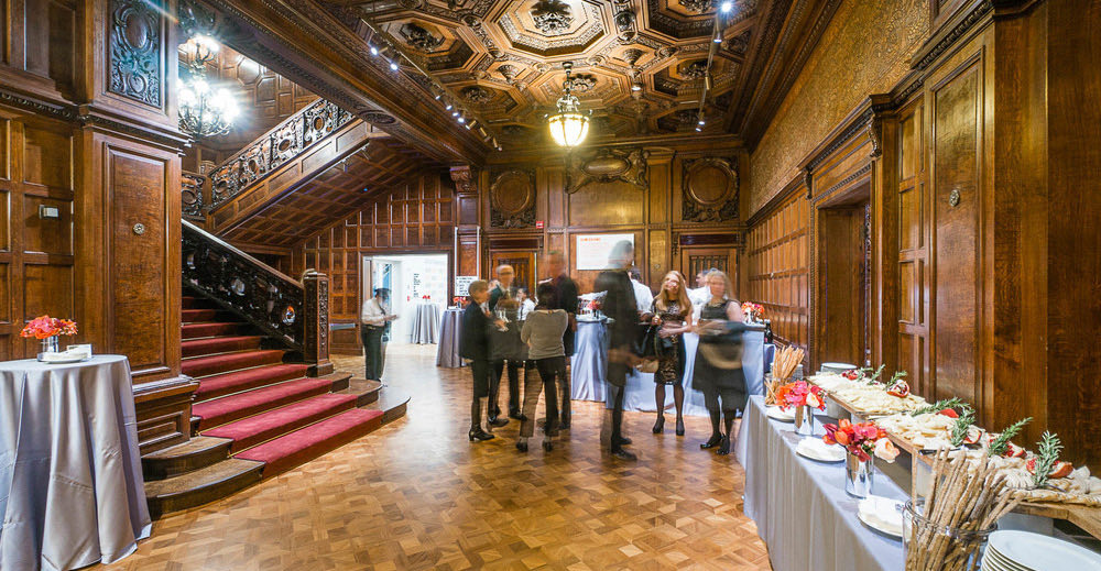 Great Hall reception with a red-carpeted stair, oak paneling and a buffet