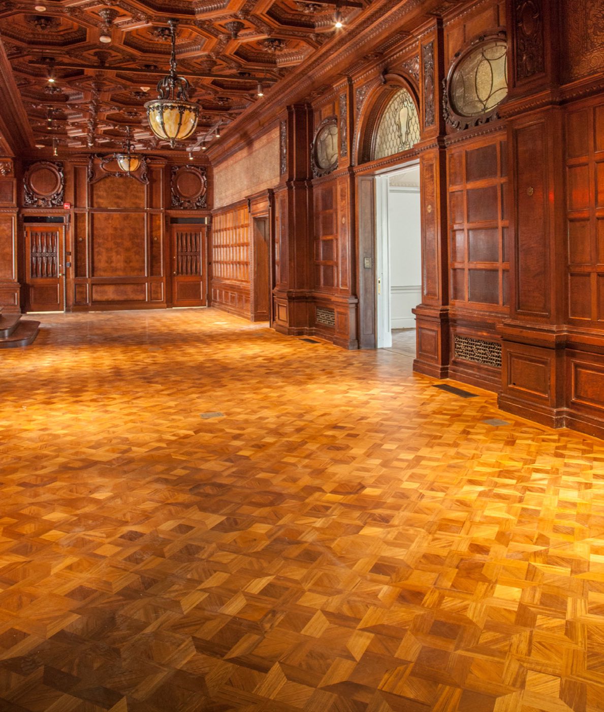 Empty Great Hall with carved oak walls, coffered ceiling and parquet floor