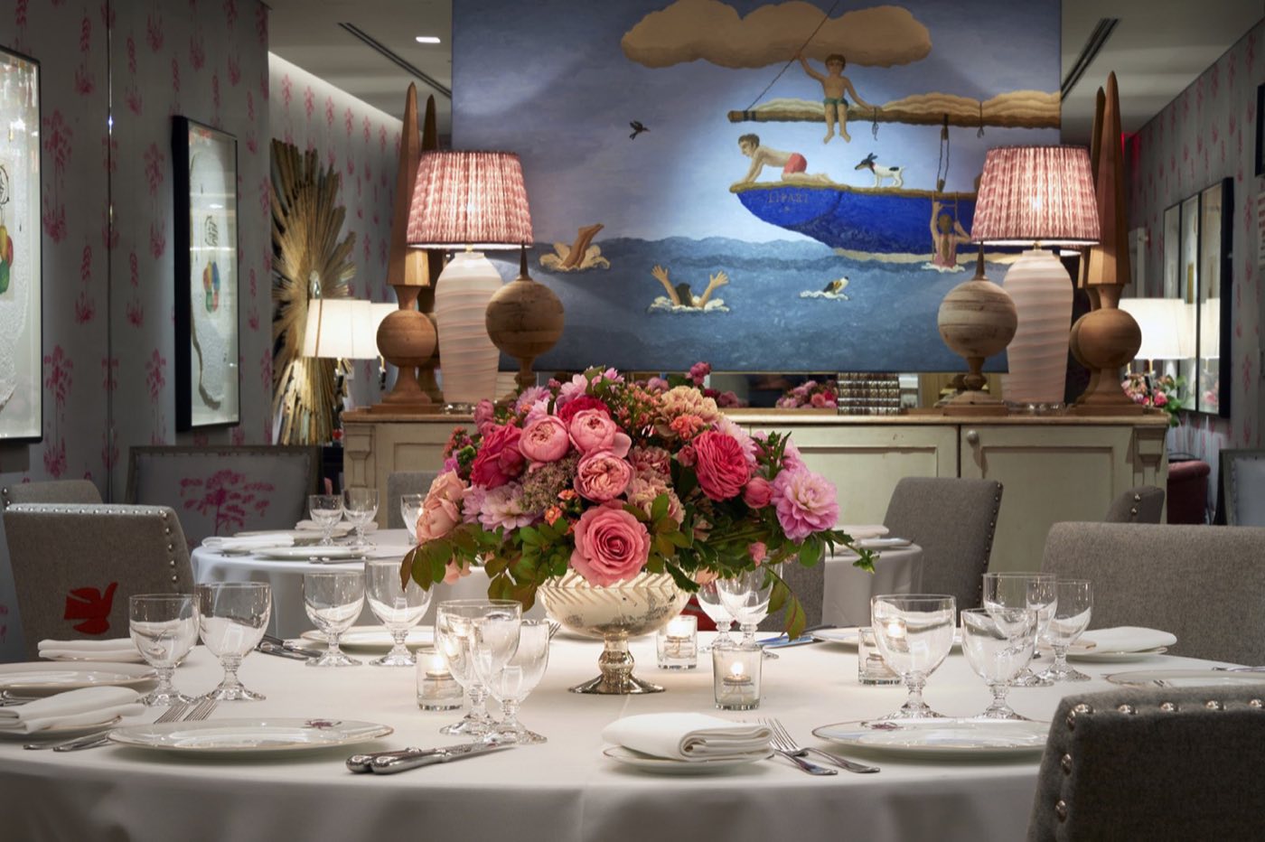 Spring room with a round dinner table, flower centerpiece and a large mural