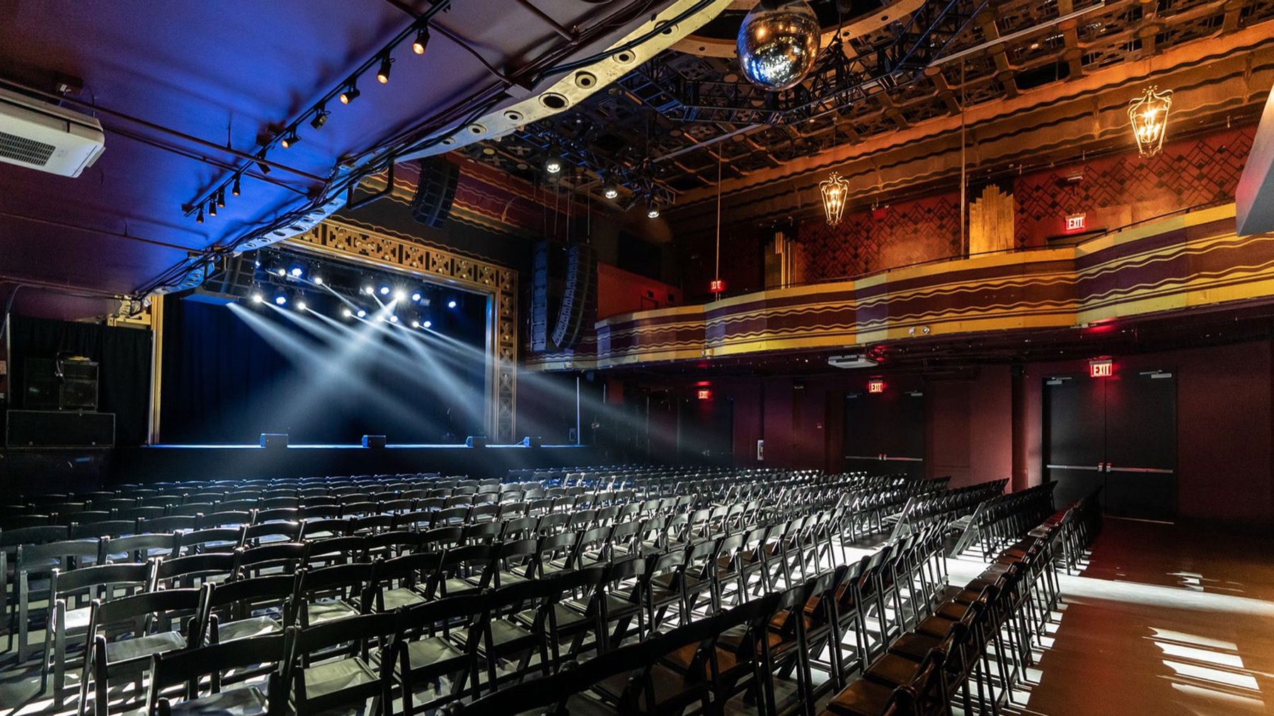 Main concert hall set theater style with rows of black chairs facing a lit stage