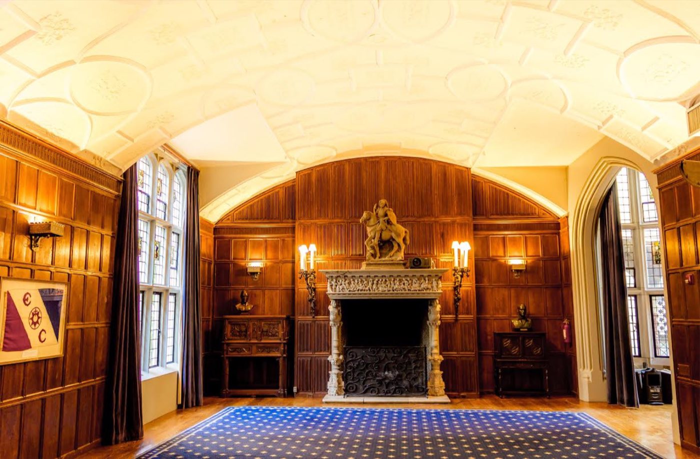 Clark Room with mahogany paneling, a carved stone fireplace and a vaulted plaster ceiling