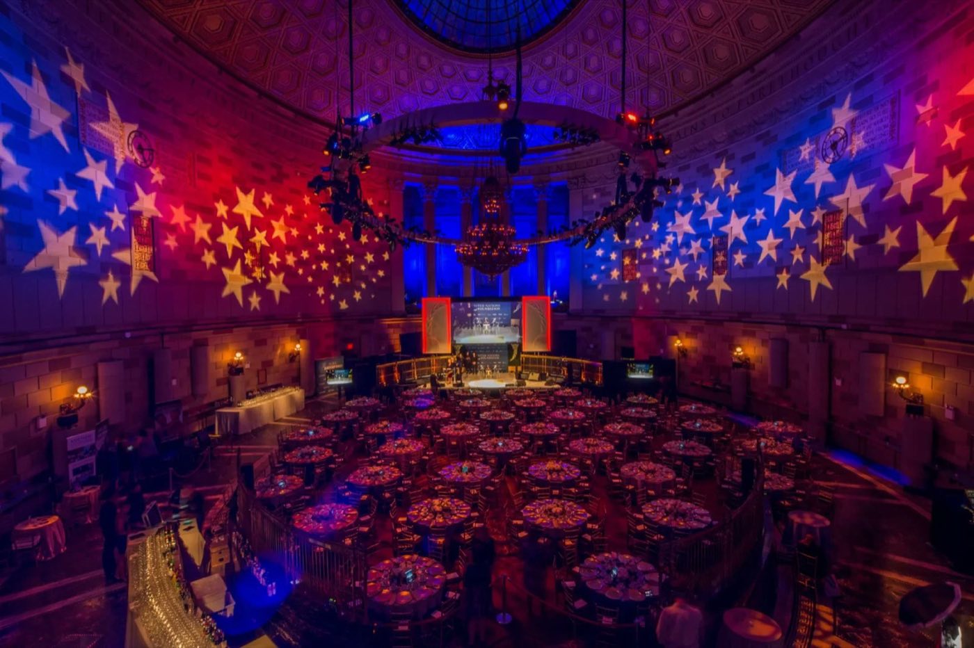 Round ballroom set for a gala dinner under the stained-glass dome with star projections