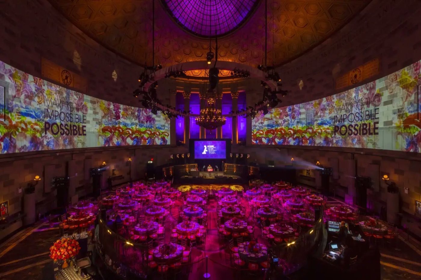 Dinner tables under the dome with wraparound video projection on the ballroom walls