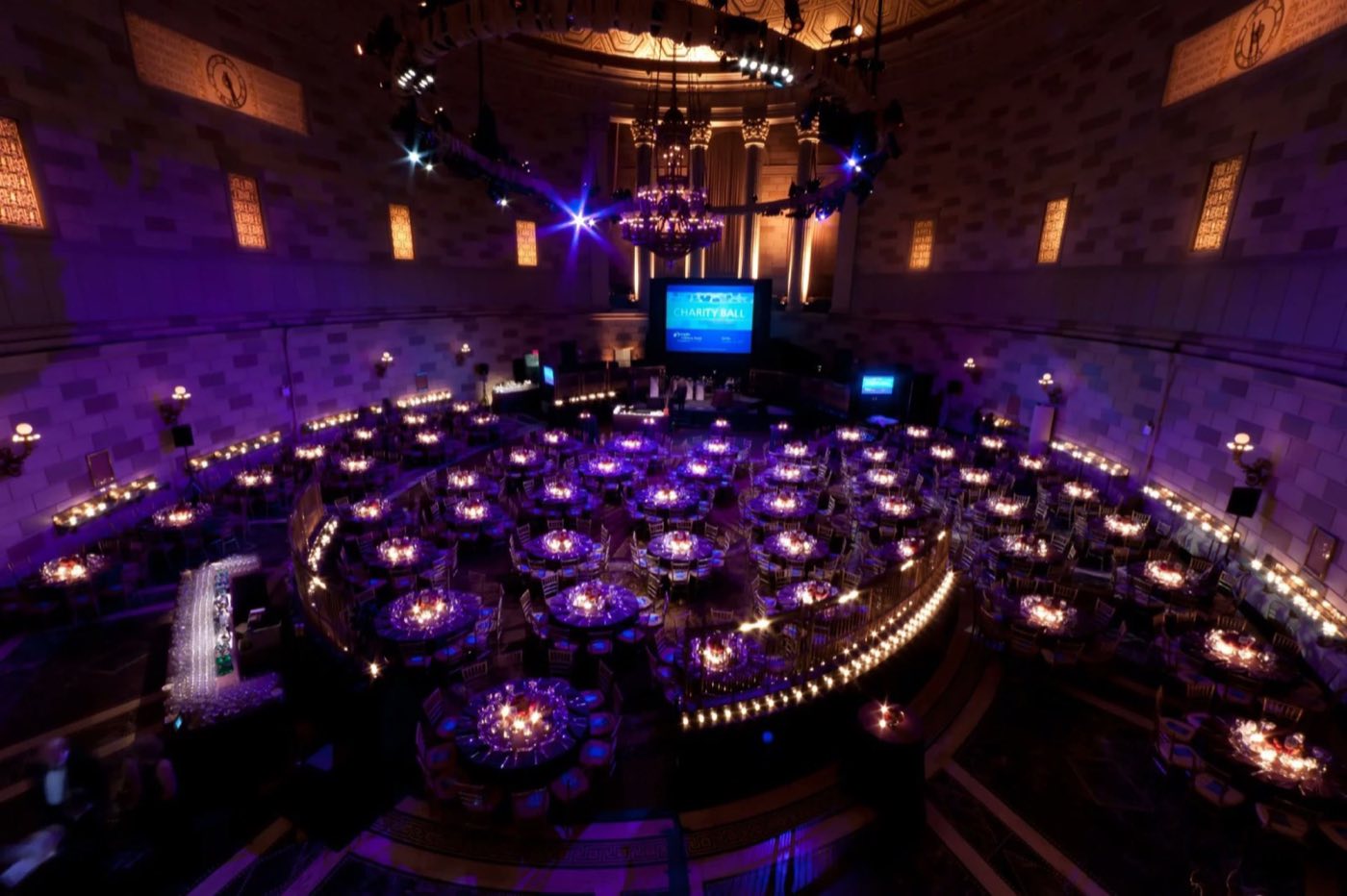 Overhead view of the oval ballroom filled with candlelit round dinner tables