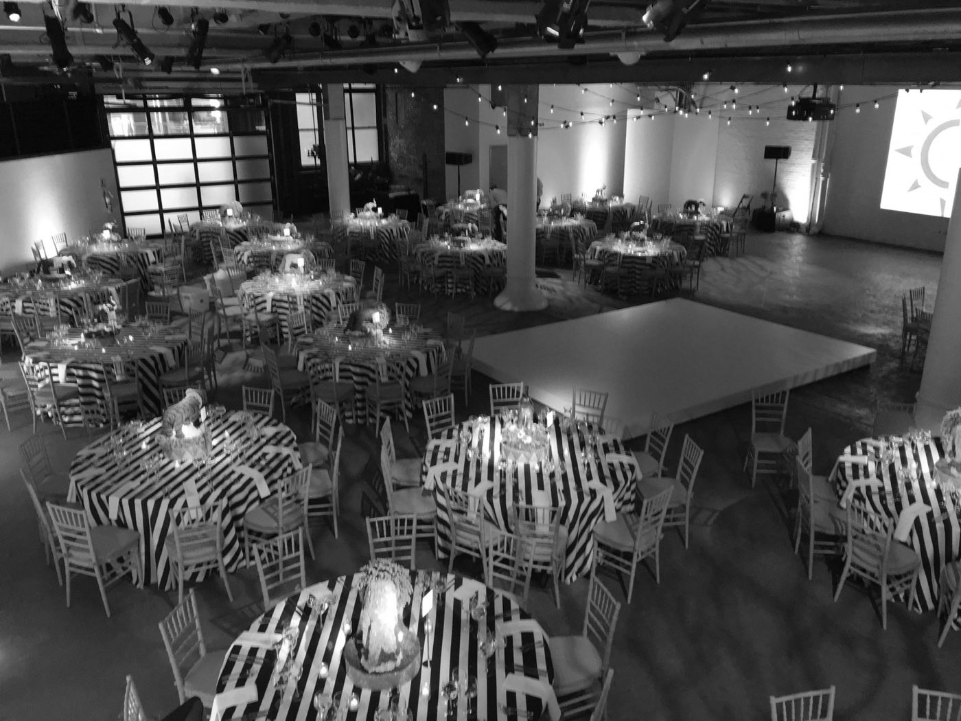 Seated dinner with round tables and a dance floor in a brick industrial hall