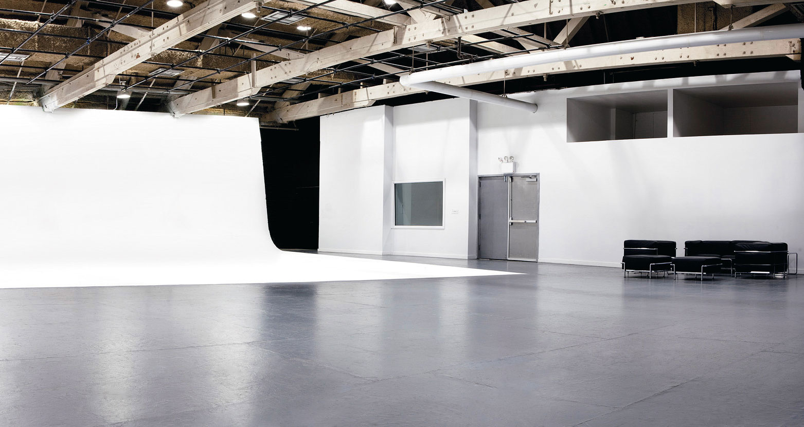 Upper floor sound stage with white cyclorama, polished floor and timber ceiling
