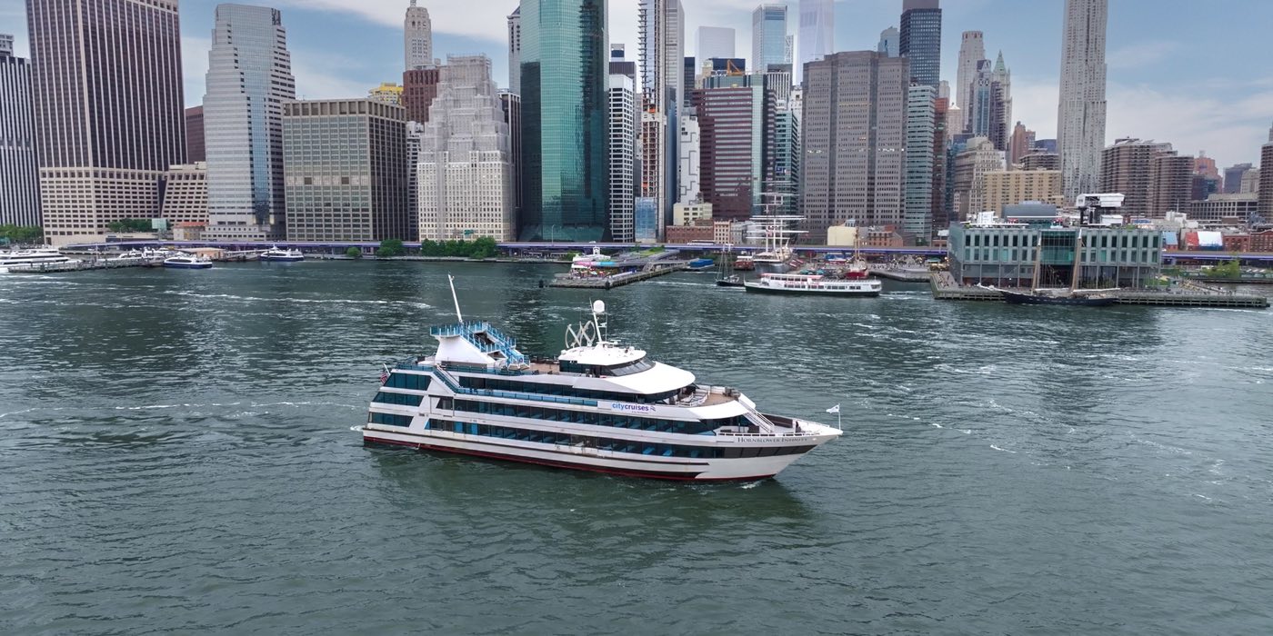 The yacht cruising in front of the Lower Manhattan skyline