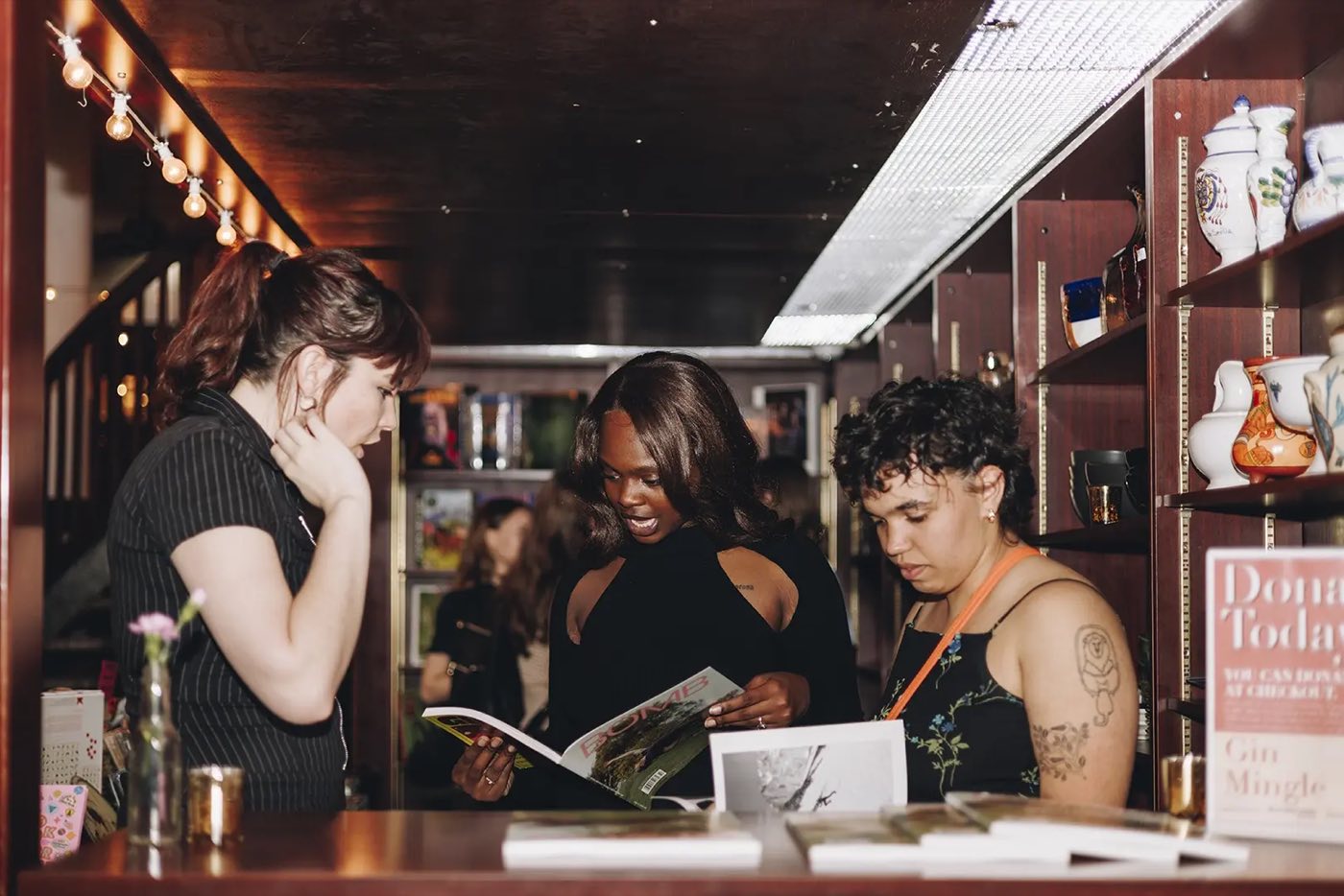 Guests browsing books at a wood counter during an evening event