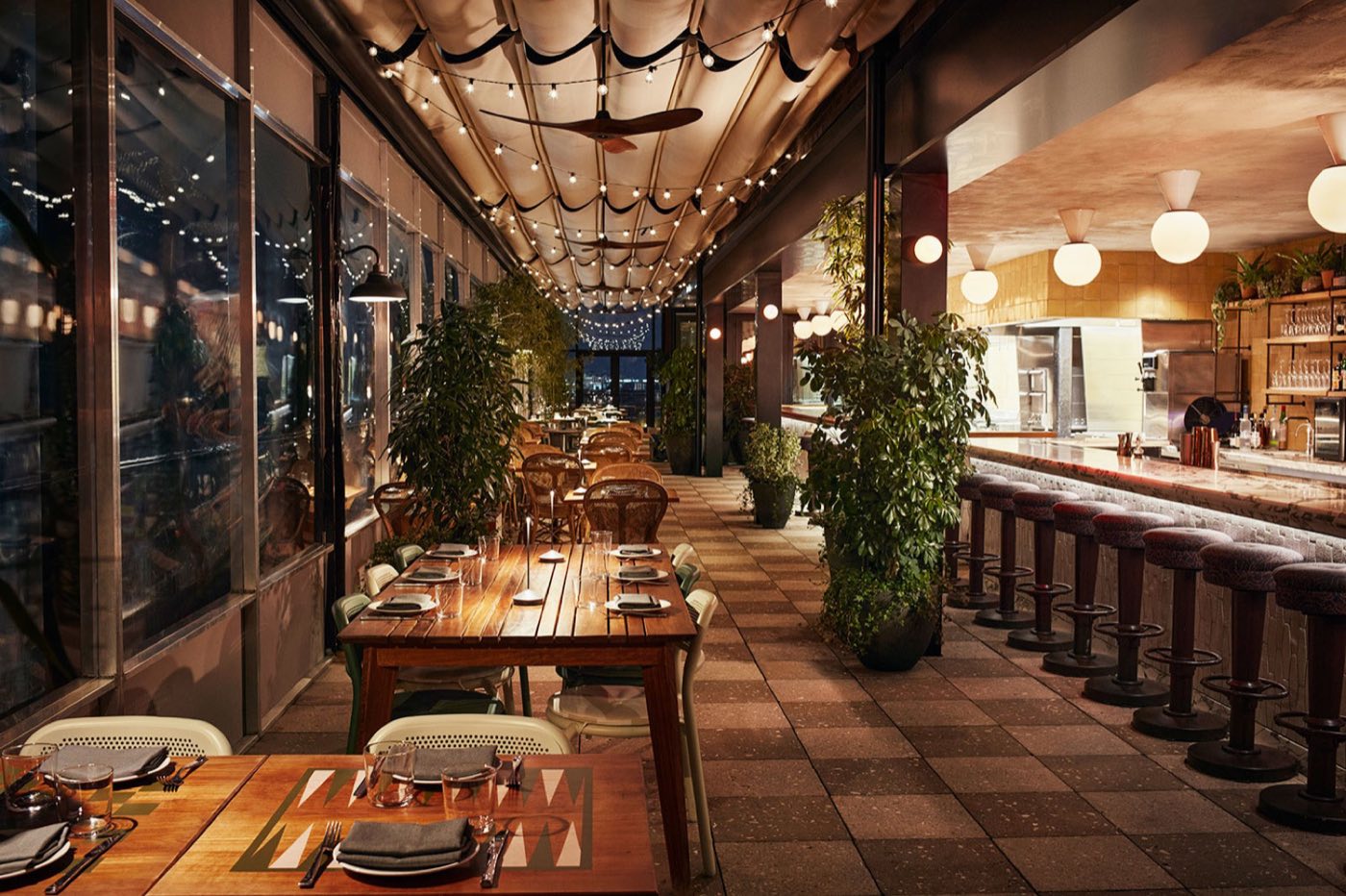 Laser Wolf dining room at dusk with bar seating and string lights