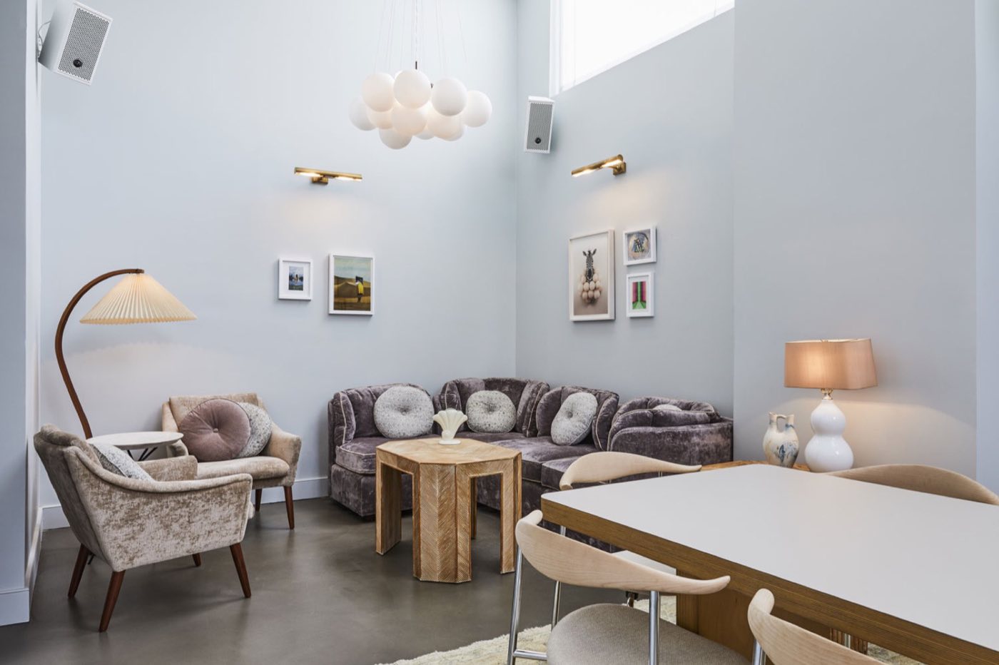 The Apartment living room set with a long dining table and lounge seating