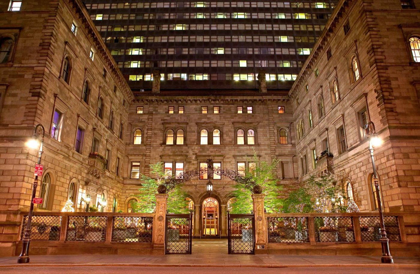 Villard Mansion courtyard at night, lit brownstone wings framing the entrance