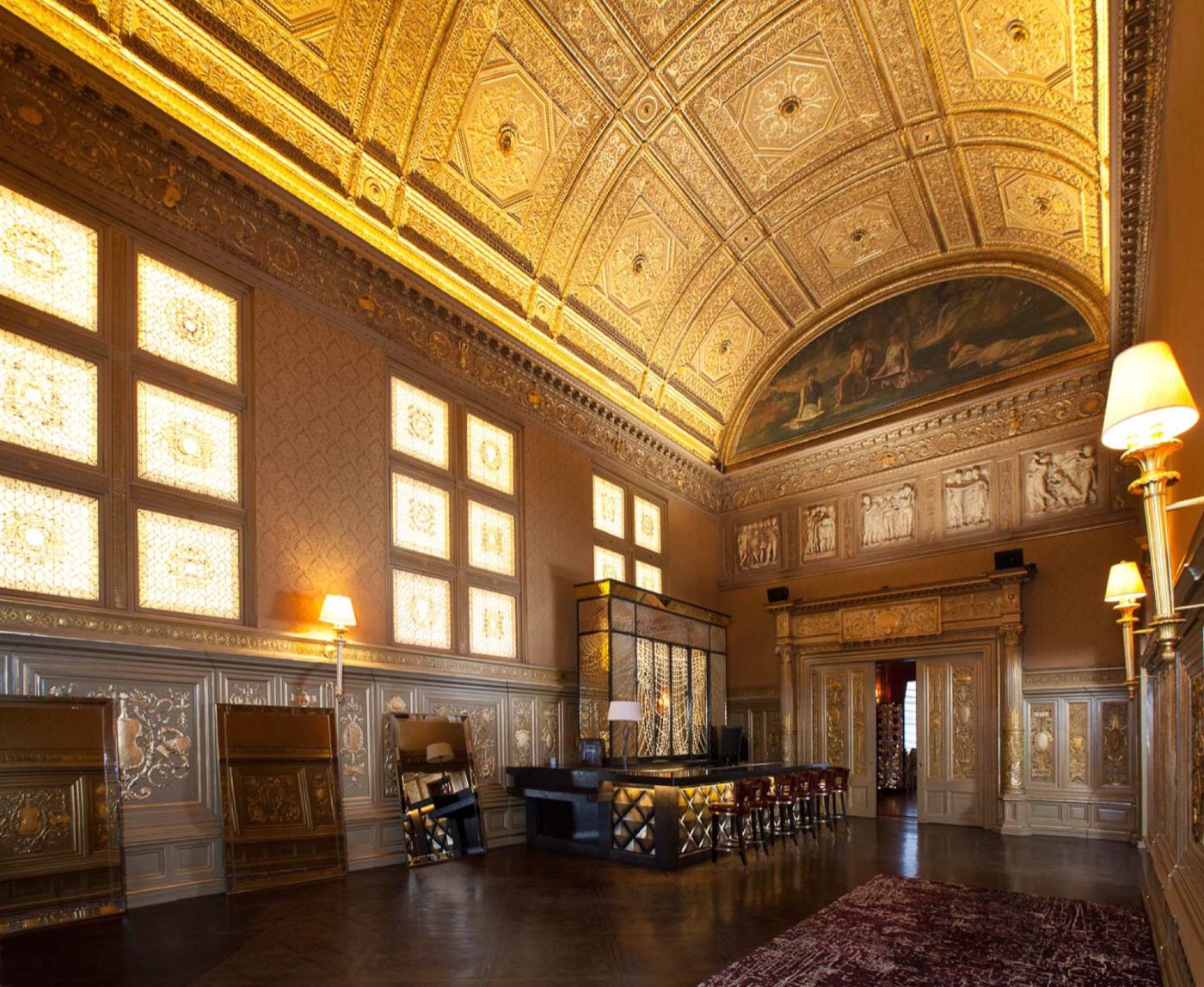 Gold Room with a barrel-vaulted gilded ceiling, lunette murals and a long bar