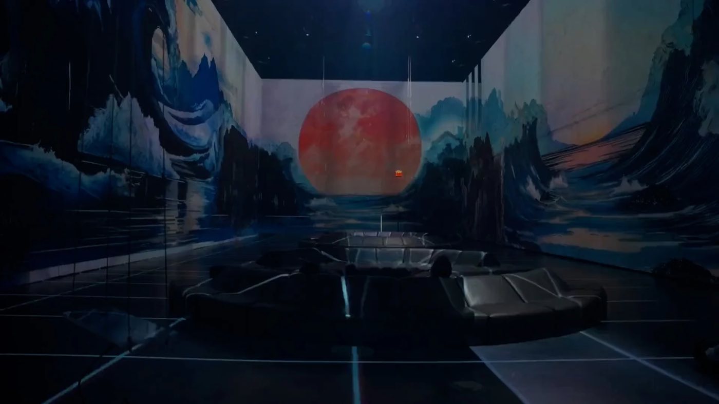 Projection hall showing a painted landscape and a red sun across the far wall