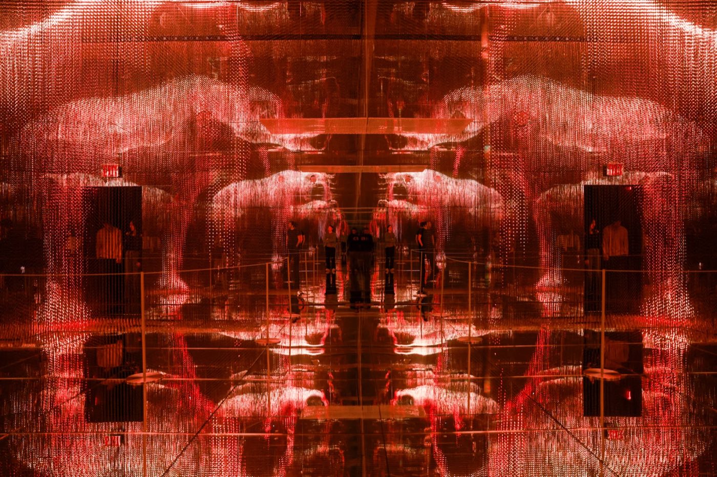 Room of suspended red lights forming a symmetrical three dimensional pattern
