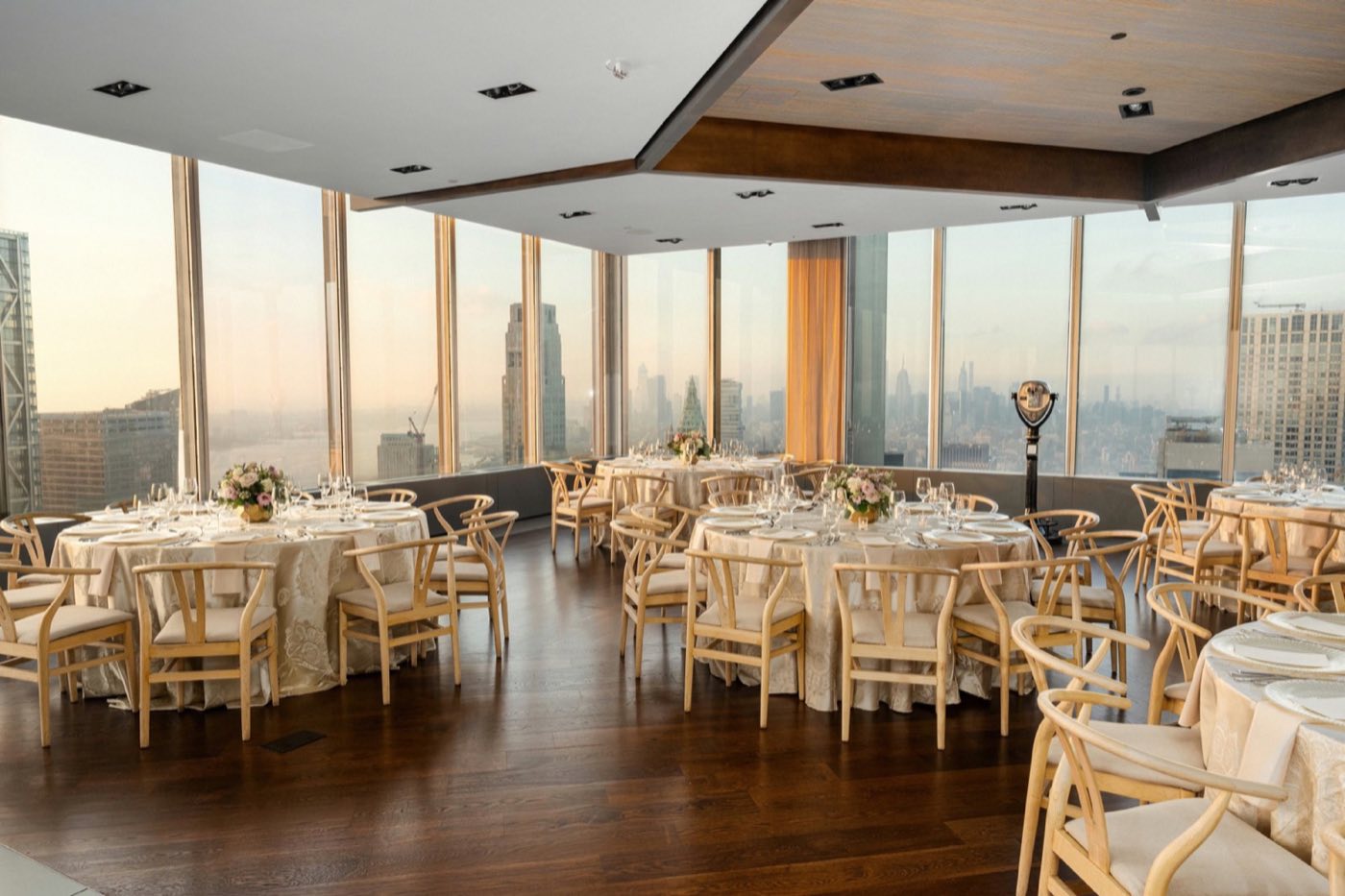 Whitman Ballroom set with round tables beside floor-to-ceiling windows over Lower Manhattan