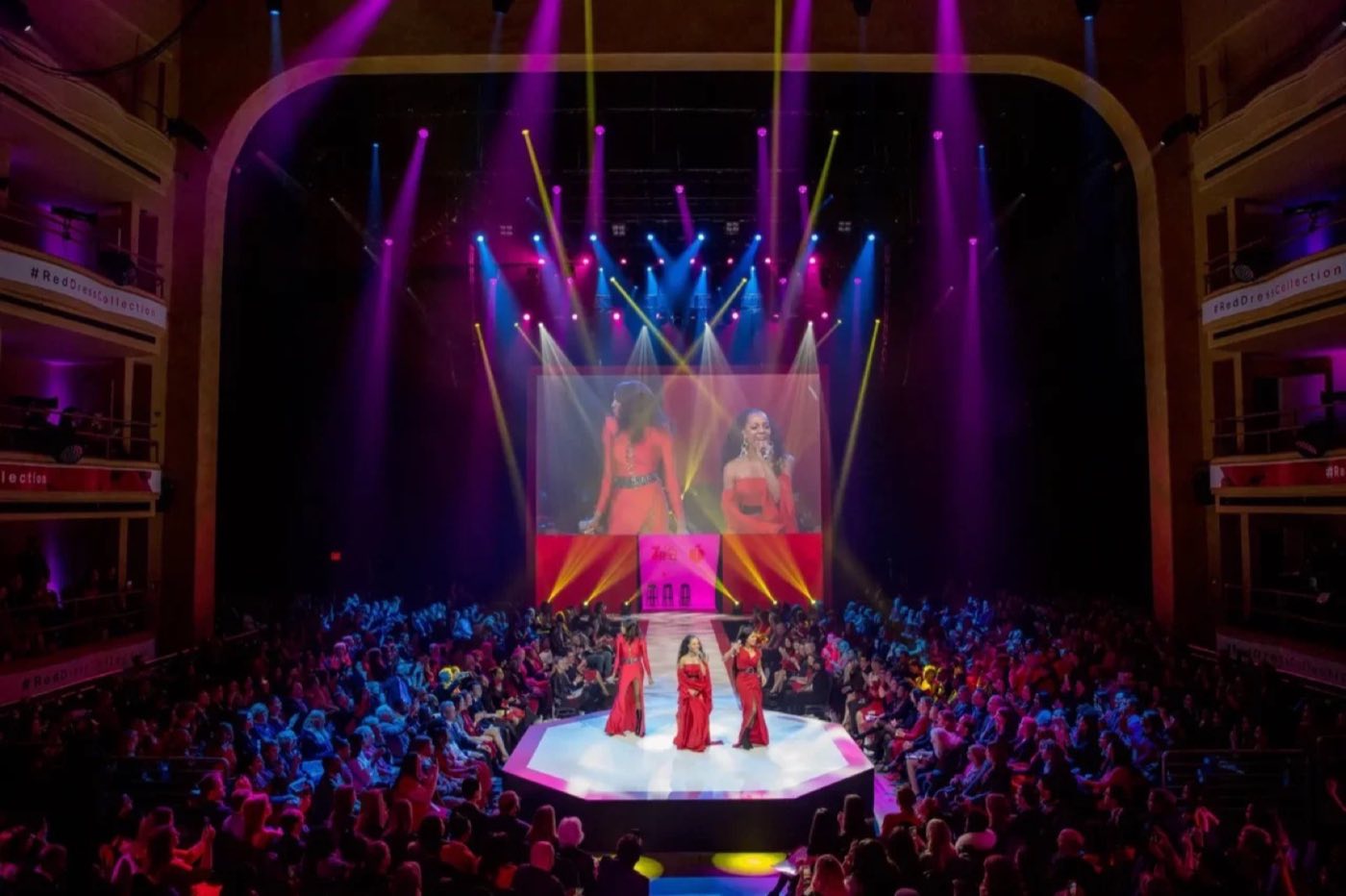 Ballroom runway show seen from the balcony with stage lighting
