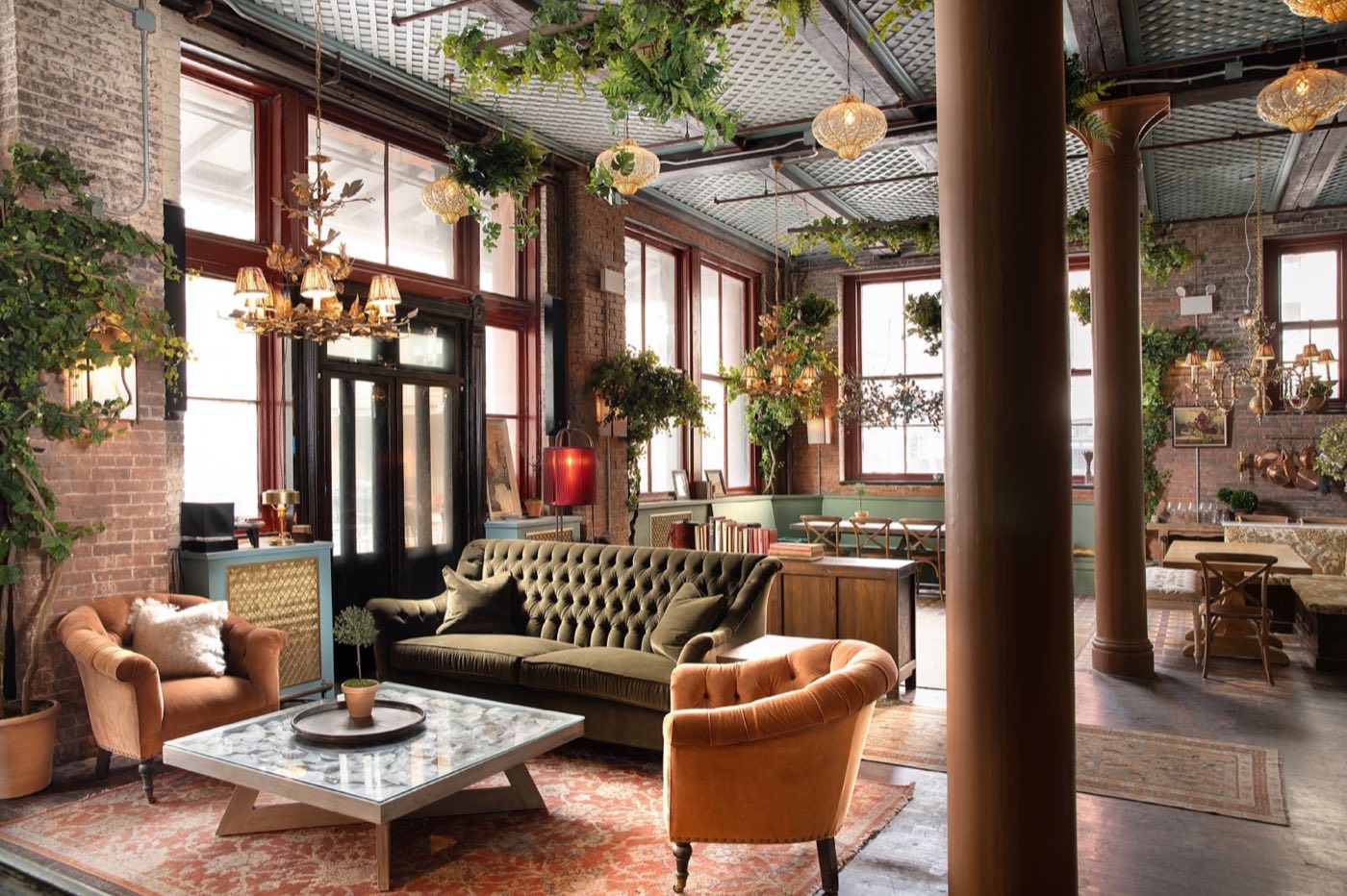 Loft lounge with green sofas, cast iron columns and tall windows