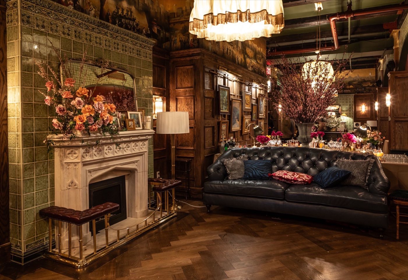 Wood paneled library room with fireplace and leather chesterfield sofa