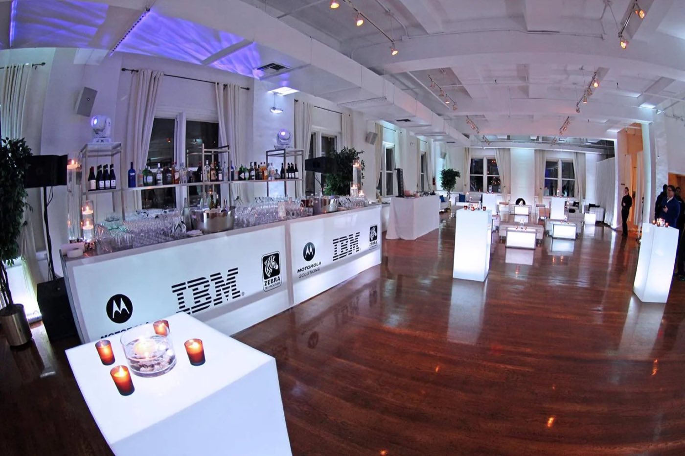 Loft set for a brand event with a long bar and wood floors
