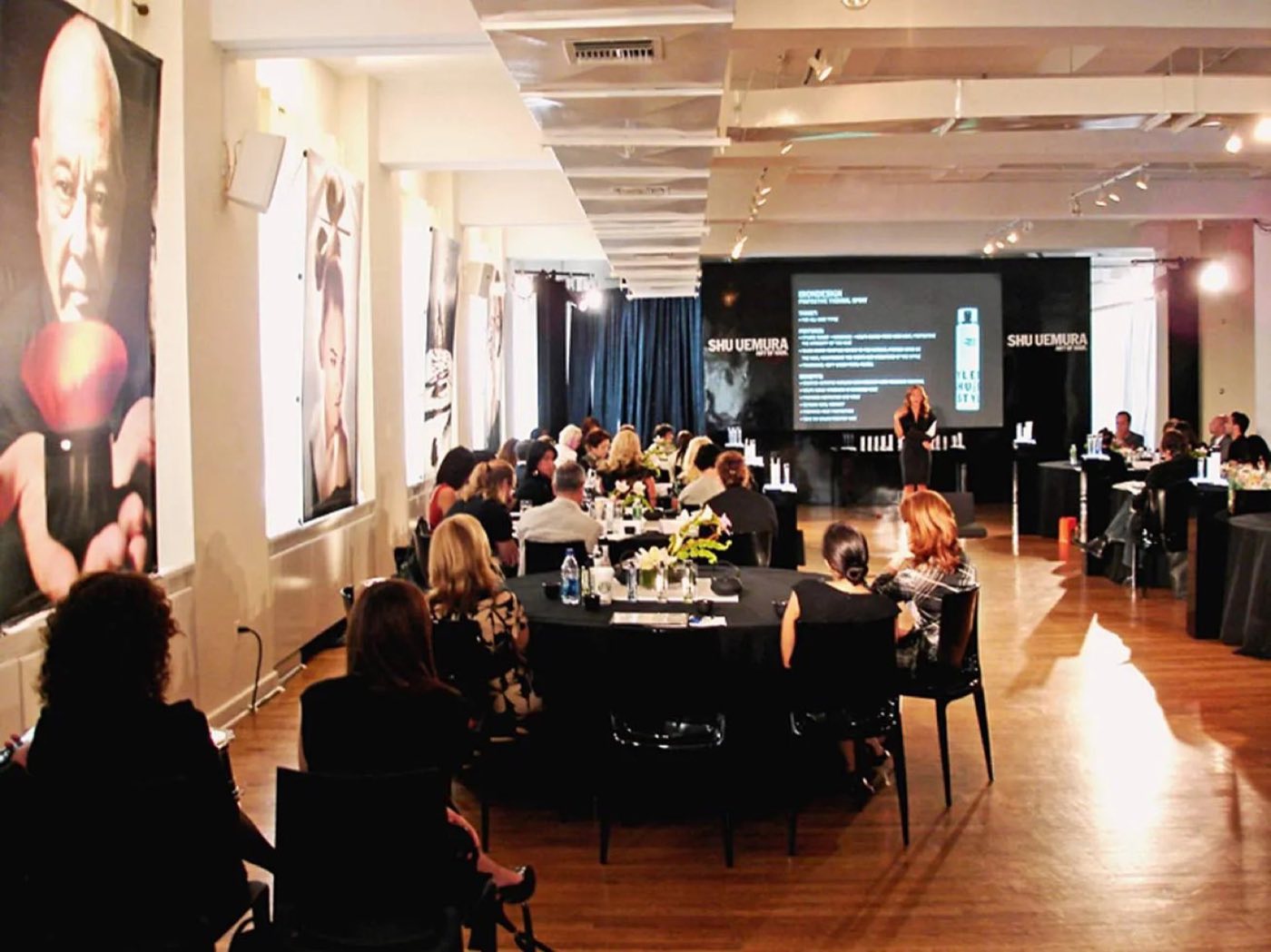 Loft dinner with round tables facing a presentation screen