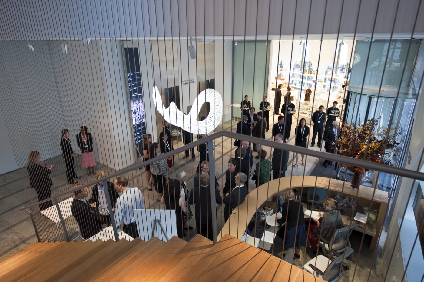 Reception guests seen from the suspended atrium stair