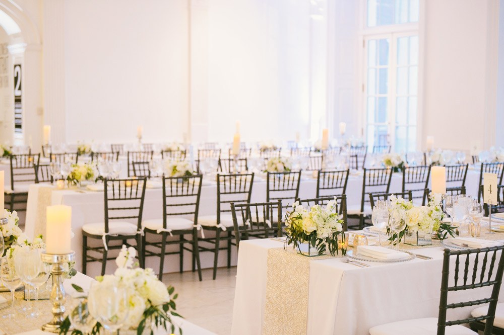 Marble Court set with long dinner tables under white light and tall French windows