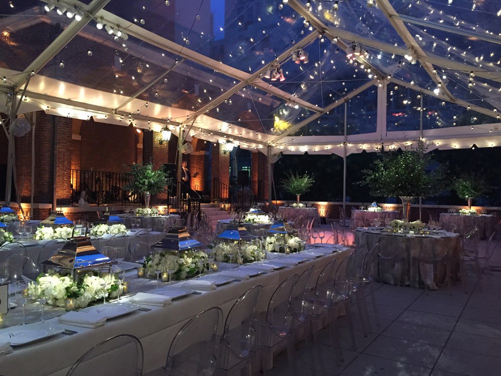 South Terrace under a clear top tent with long lit dinner tables at night