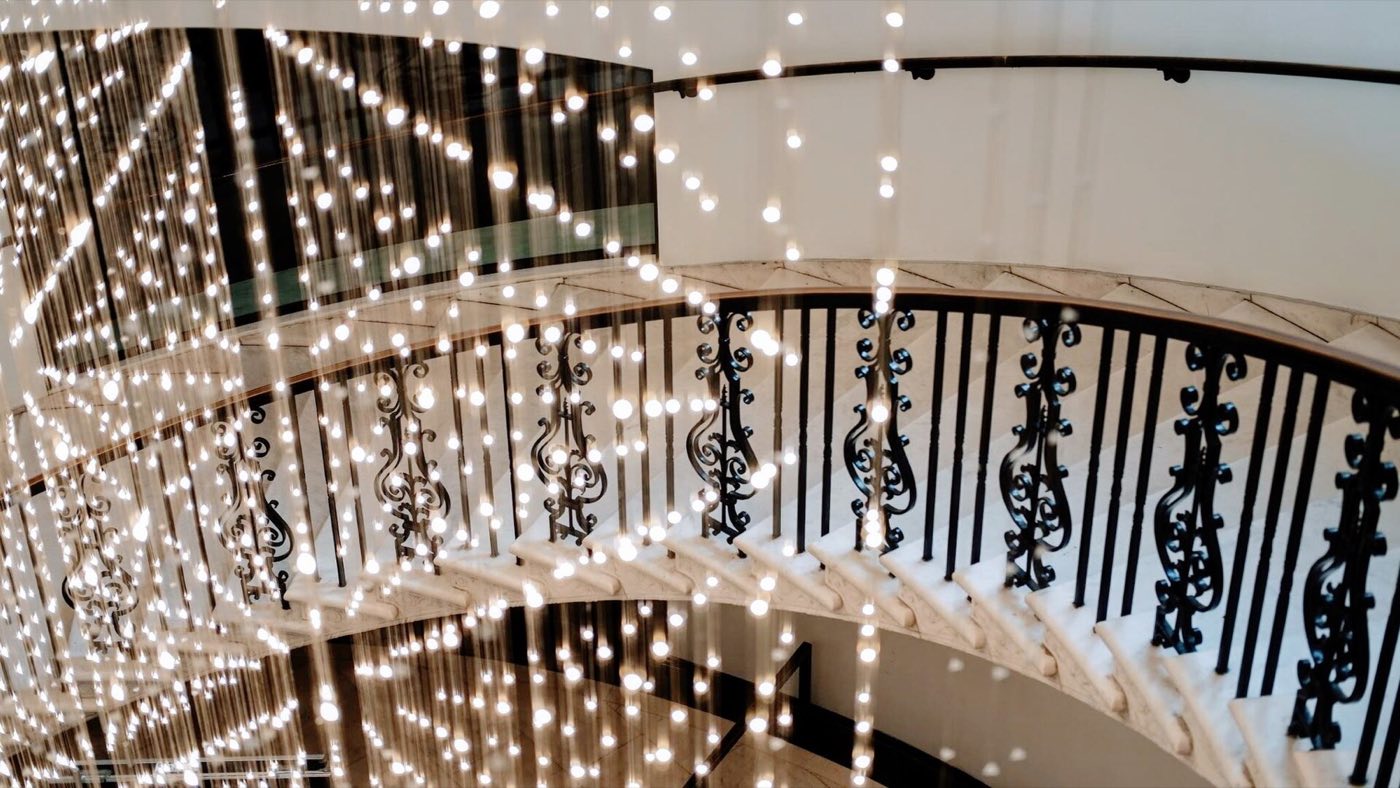 Starlight light sculpture hanging over the curved iron railing of the rotunda stair