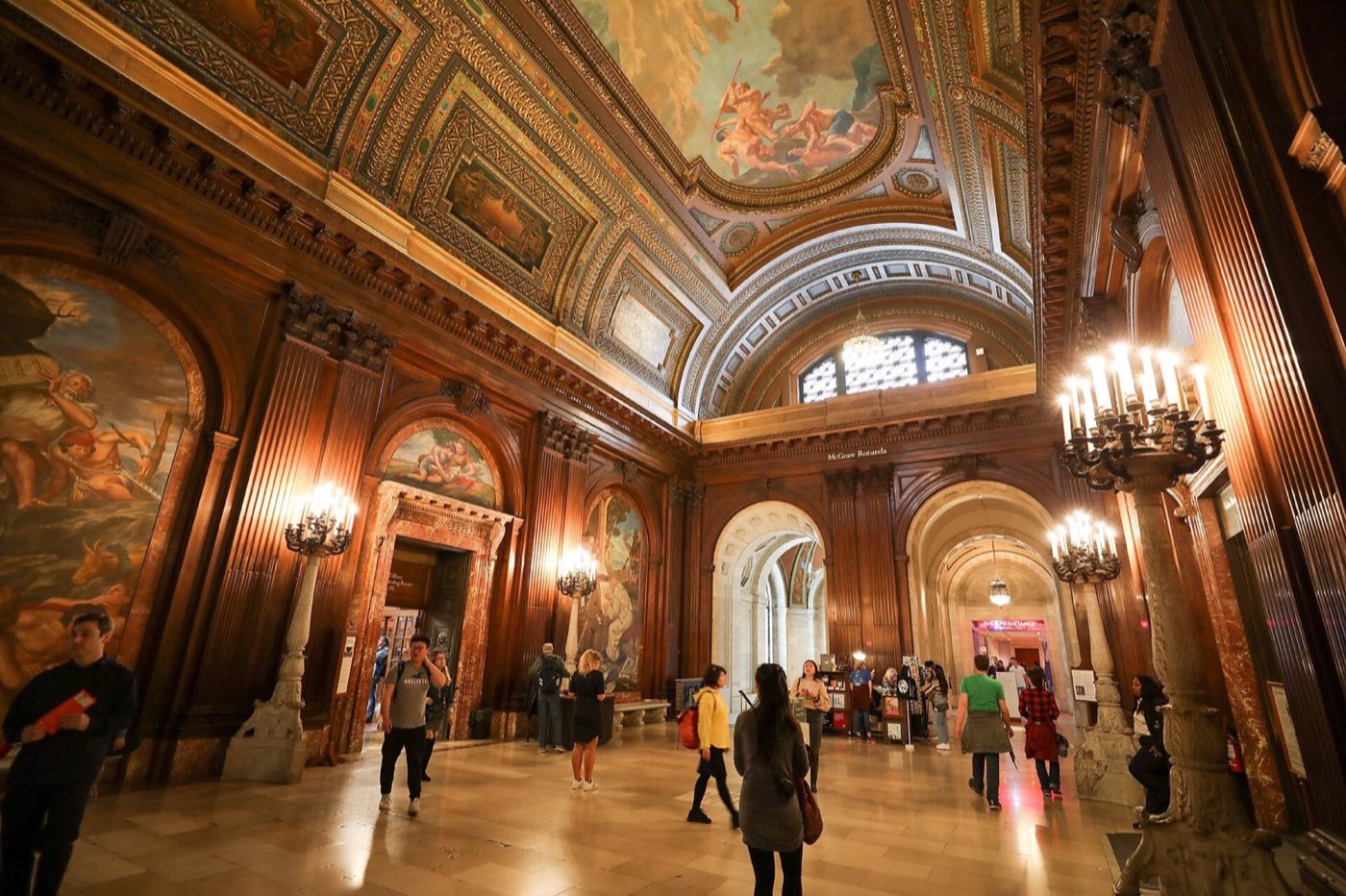 McGraw Rotunda with wood paneling, painted murals, arched doorways and a coffered ceiling