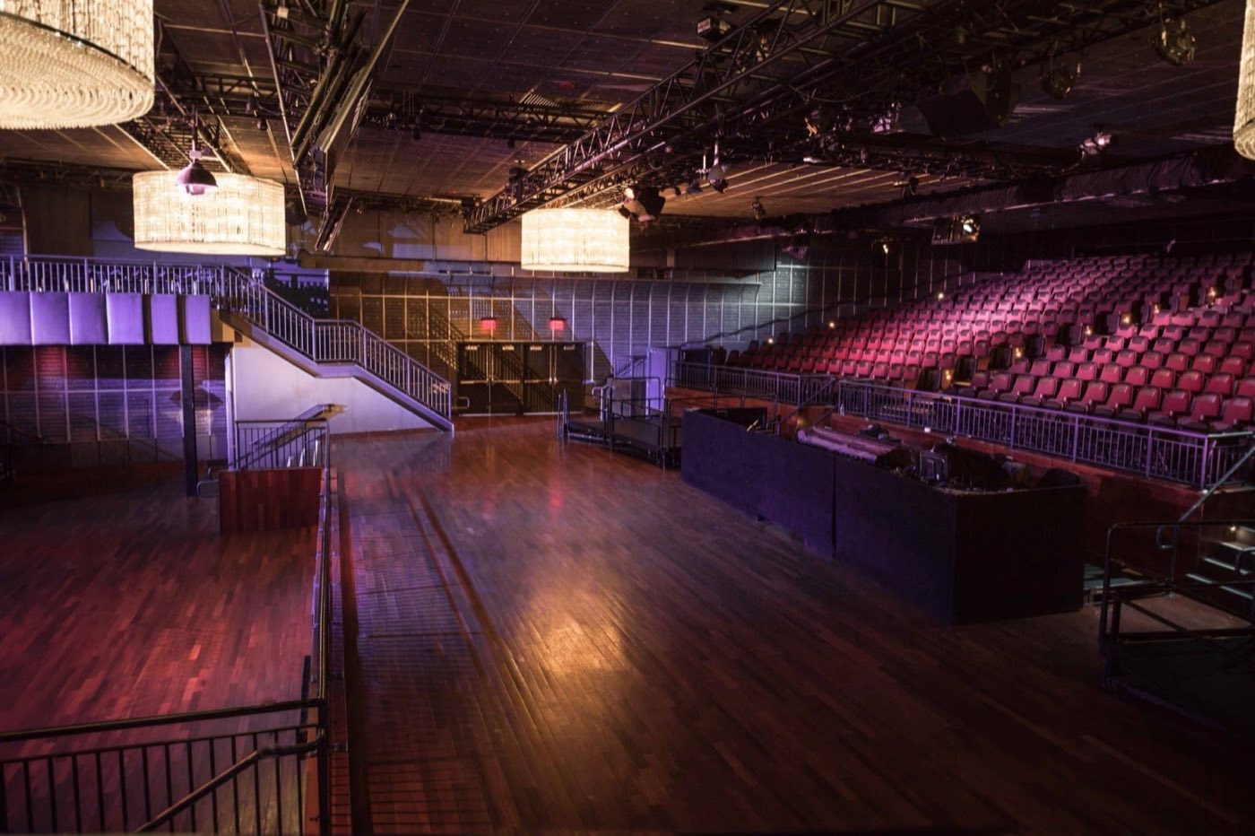 Wide view of the main floor with balcony seating and chandeliers
